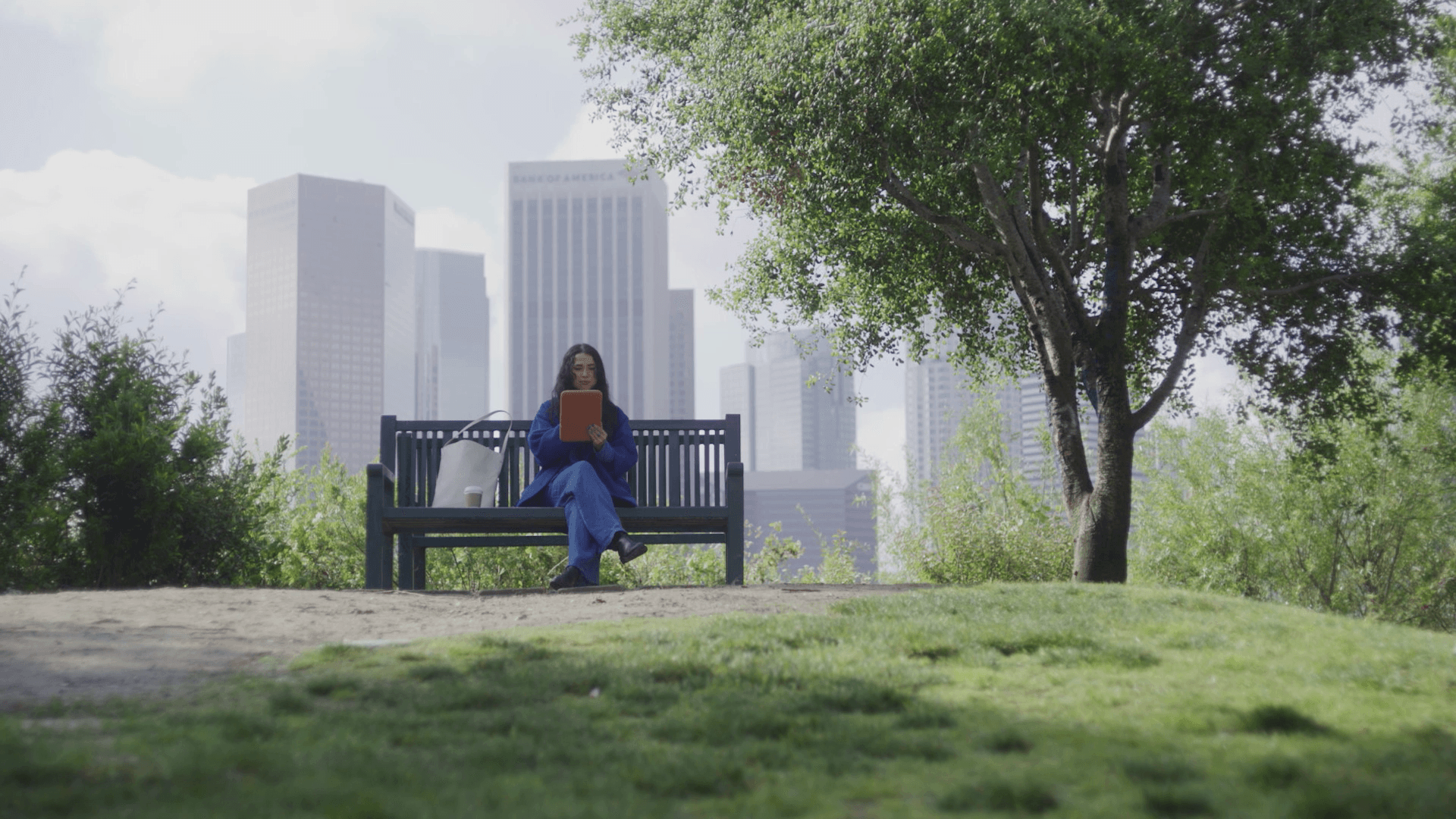 a girl sitting on a park bench with Daylight tablet in her hands